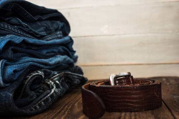 istock A stack of jeans on a wooden background and a belt 914616948