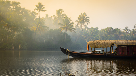 Kochi, India - 5 Feb 2017: A traditional house boat is anchored on the shores of a fishing lake in Kerala's Backwaters, India. The backwaters are a popular destination for yoga retreats and nature lovers.