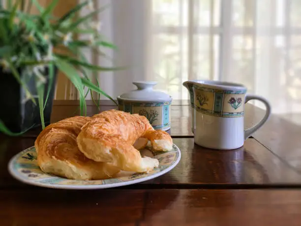Photo of Argentine afternoon tea with croissants, medialunas de Manteca in wooden table