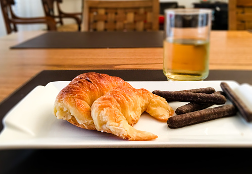 Croissants and chocolate cookies with cold drink on wooden table