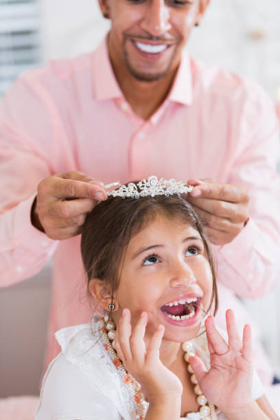 le père mettant la couronne de princesse sur sa tête petite fille - black crowned photos et images de collection