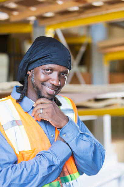istock Black man working in warehouse wearing safety vest 914620822