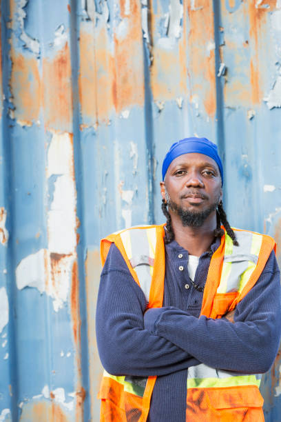 istock Worker standing in front of old semi-truck trailer 914621024