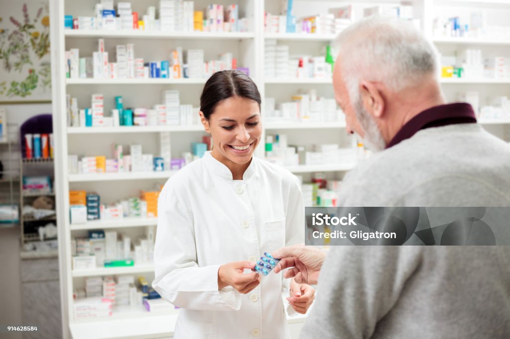 Feminino farmacêutico dar medicamentos ao cliente sênior - Foto de stock de Farmacêutico royalty-free