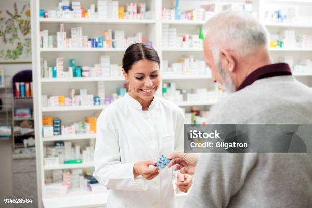 Foto de Feminino Farmacêutico Dar Medicamentos Ao Cliente Sênior e mais fotos de stock de Farmacêutico