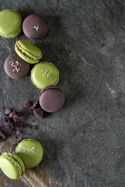 istock French dessert macaroons with pistachios and strawberries. Dark background. top view 914628800