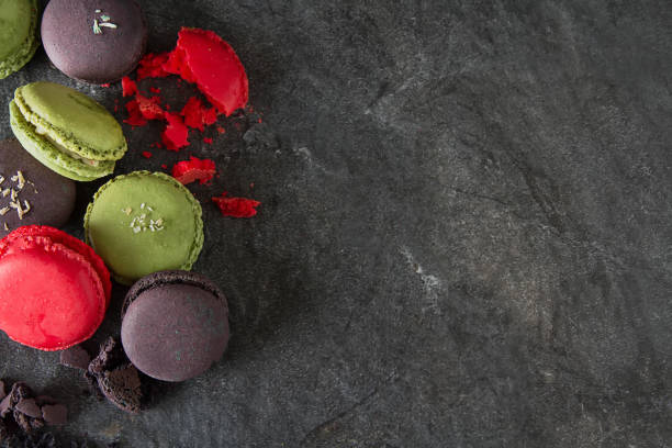istock French dessert macaroons with pistachios and strawberries. Dark background. top view 914628930