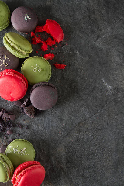 istock French dessert macaroons with pistachios and strawberries. Dark background. top view 914628942