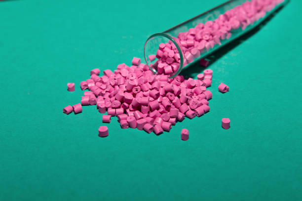 istock Plastic pallets . Plastic raw materials in granules for industry. Polymeric dye pink on a turquoise background. Plastic granules after processing of waste polyethylene and polypropylene.Polymer. 914629136