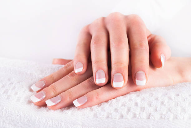 istock Hands with french  nails manicure on white towel 914633686