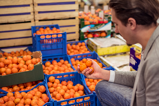 Man checking fresh mandarins in fruit warehouse