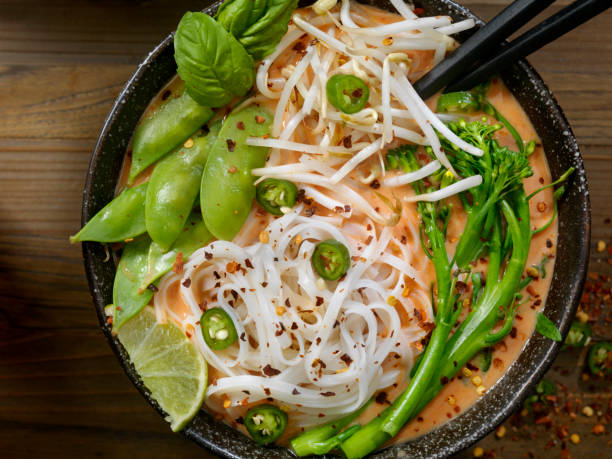Red Curry Noodle Soup with Broccolini, Bean Sprouts and Fresh Basil, Thai Red Curry Noodle Soup with Broccoli, Bean Sprouts, Fresh Basil, Lime and Chili Flakes fusion food stock pictures, royalty-free photos & images