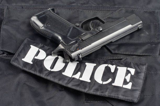 istock Police concept - handgun on black uniform background 914647370