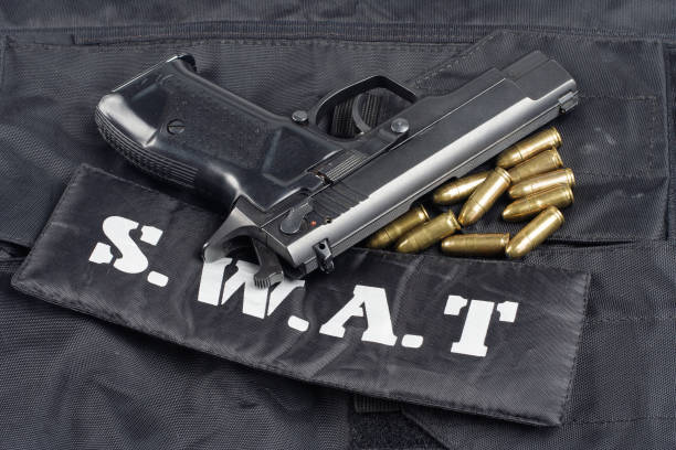 istock SWAT teams concept -handgun on black uniform background 914647398