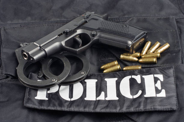 istock Police concept - handgun on black uniform background 914647446