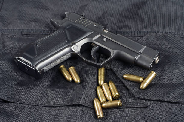 istock Police concept - handgun on black uniform background 914647610