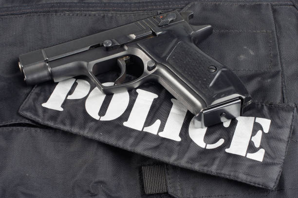 istock Police concept - handgun on black uniform background 914647650