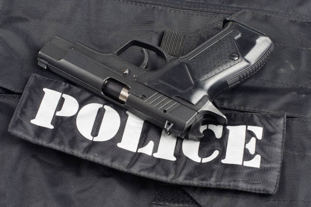 istock Police concept - handgun on black uniform background 914647808