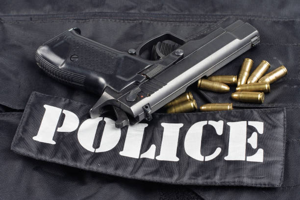 istock Police concept - handgun on black uniform background 914647900