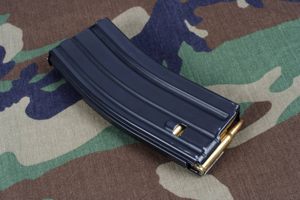 rifle de los estados unidos ejército m-16 revista con cartuchos sobre fondo uniforme camuflaje - high capacity magazine fotografías e imágenes de stock