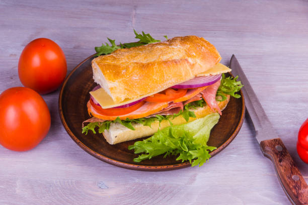 istock Fresh sandwiches with ham, cheese, lettuce, onions and tomatoes close-up 914658816