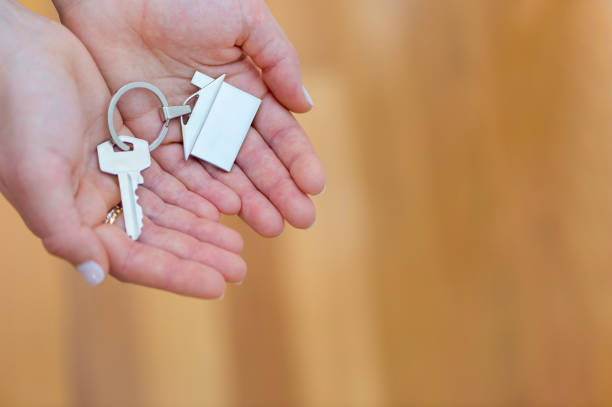 istock Woman offering a house key. 914668664