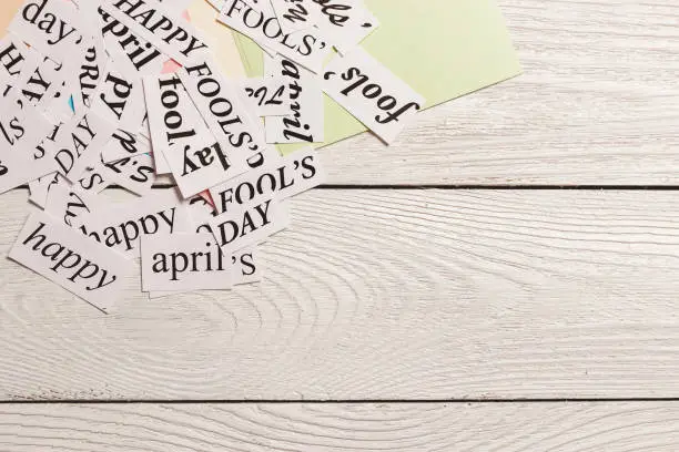 Photo of printed words Happy April Fools Day on wooden background