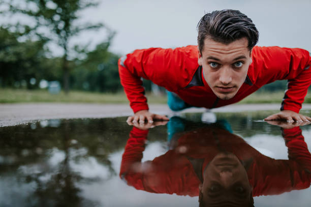 istock Young athletic man exercising after rainy day 914673032