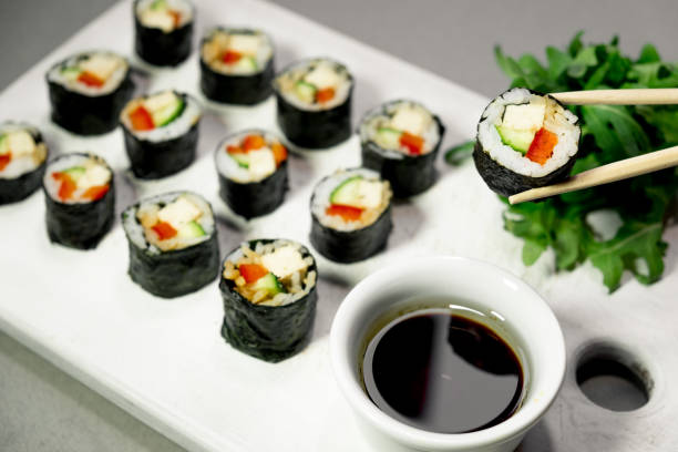 istock Vegan sushi rolls with quinoa, vegetables and soy-nut sauce on a white plate, light background. Vegan Healthy Food Concept. 914673170