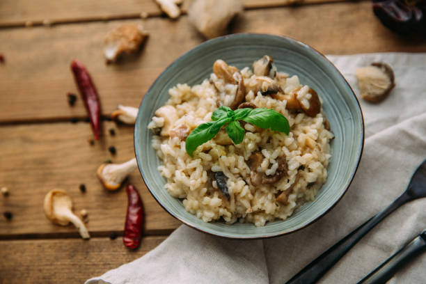 Risotto with mushrooms on an old wooden background. Rustic style. stock photo