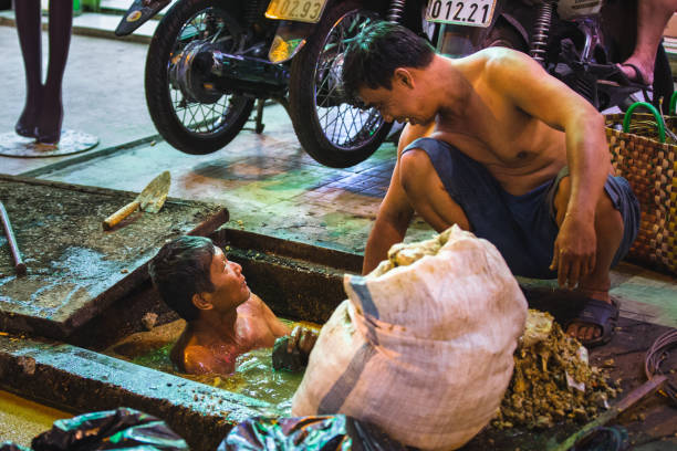 Manila, Philippines - March 05, 2022: Slums and illegal settlements scattered across the metropolitan area in downtown near the street. People do daily work.