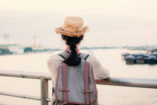 istock Rear View Of Woman Leaning On Railing While Standing Against River During Sunset 914696086