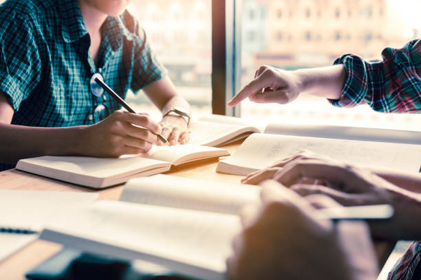 istock Group of students studying and brainstorming on desk in a public library. 914729864