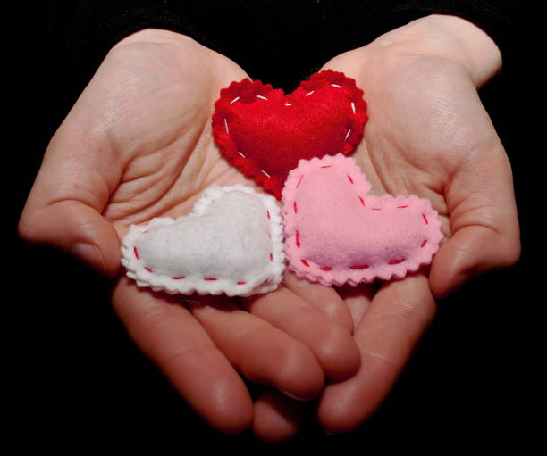istock A girl's cupped hands holding three hearts 914730008