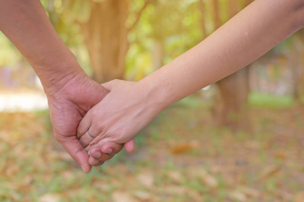 istock Loving couple holding hands on blurred background with sun light effect for Valentine's day and love concept 914739286