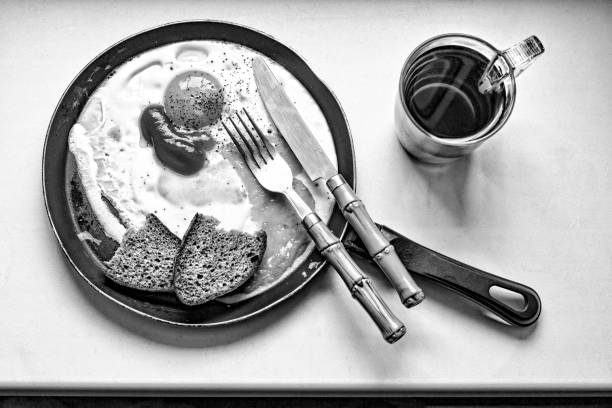 foto in bianco e nero, colazione, caffè, uova fritte, in una frittura - on top of pan eggs scenics foto e immagini stock