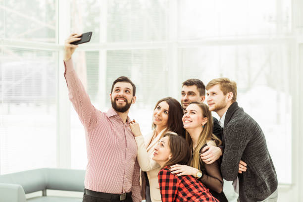 istock friendly business team taking a selfie while standing near window in office 914746326