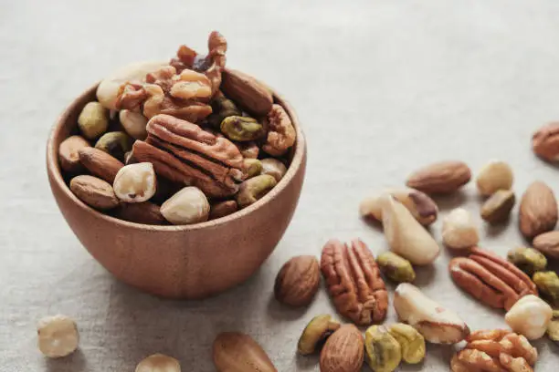 Photo of mixed nuts in wooden bowl, healthy fat and protein food and snack, ketogenic diet food