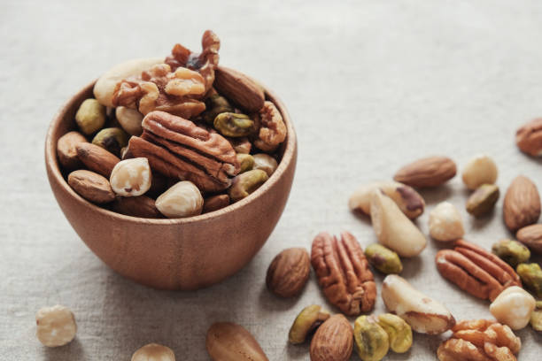 mixed nuts in wooden bowl, healthy fat and protein food and snack, ketogenic diet food - lanchar imagens e fotografias de stock