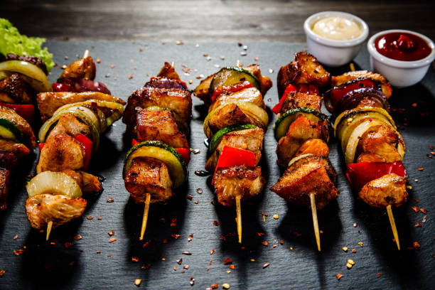 istock Kebabs - grilled meat and vegetables on wooden background 914754330