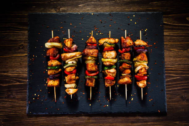 istock Kebabs - grilled meat and vegetables on wooden background 914754396