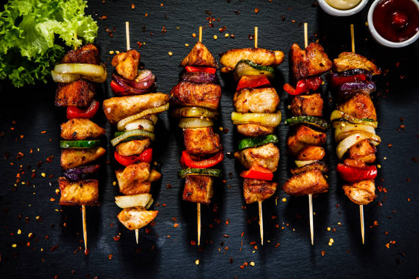 istock Kebabs - grilled meat and vegetables on wooden background 914754572