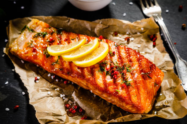 Fish dish - salmon steak and vegetables Fish dish - fried salmon and vegetables on white background grilled salmon stock pictures, royalty-free photos & images