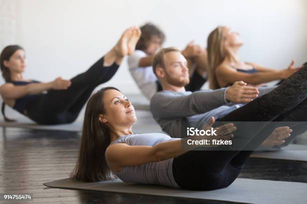 Photo libre de droit de Groupe De Jeunes Sportifs Dans La Pose De Bateau banque d'images et plus d'images libres de droit de Méthode Pilates - Méthode Pilates, Apprentissage, Exercice physique