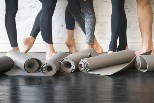 tapis de yoga en rouleau - yoga class caucasian young adult group of people photos et images de collection