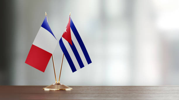 istock Cuban And French Flag Pair On A Desk Over Defocused Background 914755780