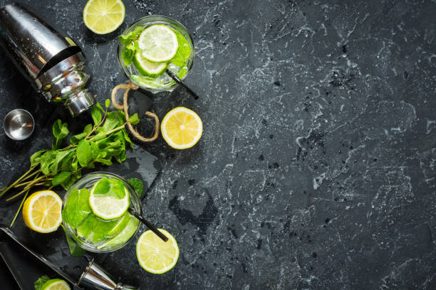 istock Mojito cocktail with lime and mint in highball glass on a stone table. Drink making tools and ingredients for cocktail. Copy space 914759712
