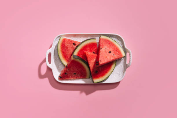 istock Fresh sliced watermelon in white dish on pink background. 914762932