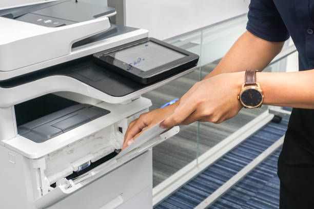 istock close up businessman with black shirt put paper sheet into printer feeder for copying documents 914764636