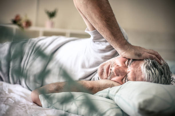 Pain in head. Senior man lying on bed and having headache. Space for copy. man sleeping on bed stock pictures, royalty-free photos & images